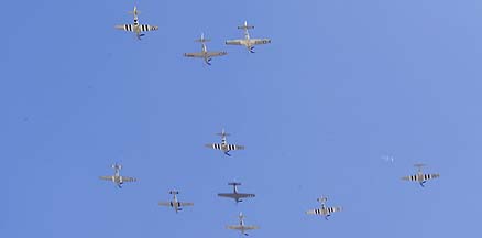 9 Mustangs and an Apache in formation